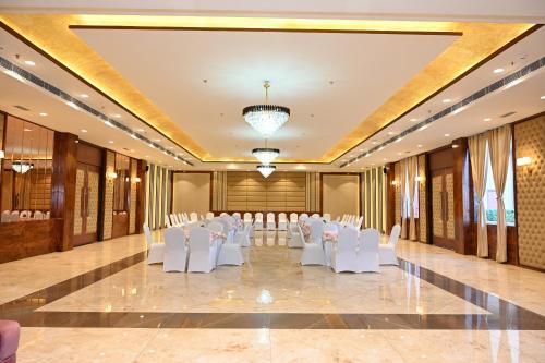 a banquet hall with white chairs and a set up for a wedding at Hotel Shyamleela in Khātu