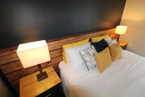 a bedroom with a bed with a wooden headboard and a lamp at Seagrass a luxurious gem by the sea in Youghal