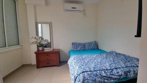 a bedroom with a bed and a dresser and a mirror at Apartments Petah Tiqwa - Bar Kochva Street in Petaẖ Tiqwa