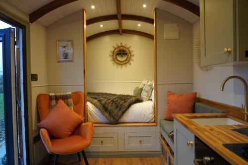 a mirror in a kitchen with a bed in it at The Dragonfly - Luxury Lakeside Shepherds Hut in Cotham