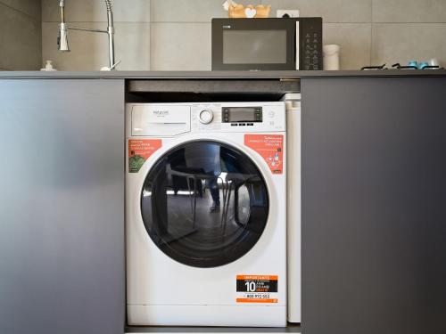 a microwave and a washing machine in a kitchen at DON PEPPE ROOMS : Villaggio Green in SantʼAngelo in Formis