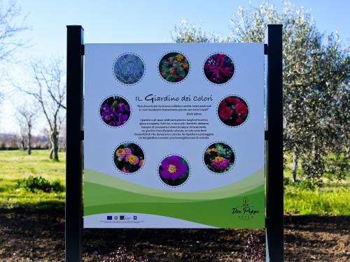 a sign in a park with flowers on it at DON PEPPE ROOMS : Villaggio Green in SantʼAngelo in Formis