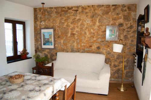 a living room with a white couch and a table at Casa en Villa Termal Las Caldas in Las Caldas