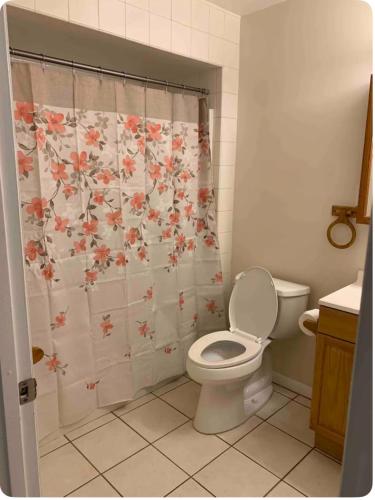 a bathroom with a toilet and a shower curtain with flowers at Little Cute Home in Beverly Hills