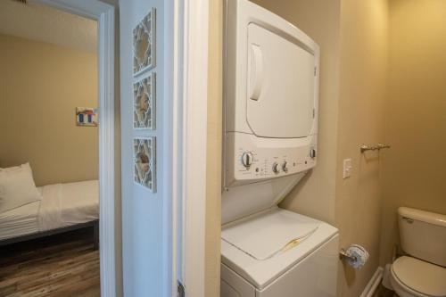 La petite salle de bains est pourvue de toilettes et d'un sèche-linge. dans l'établissement Century Oaks Townhome, à Gulfport