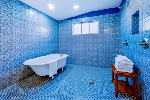 baño con paredes de azulejos azules y bañera en Old Spanish House- C, The Madeleine Suite, en Biloxi