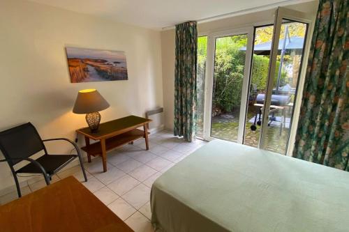 une chambre avec un lit, un bureau et une fenêtre dans l'établissement La Villa FranceYann, à Carnac