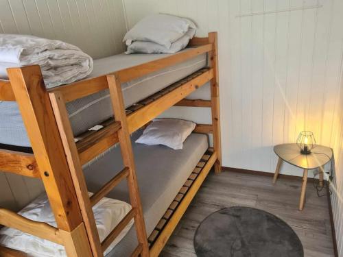 - deux lits superposés dans une chambre avec une table dans l'établissement Maisonnette 4/6p. piscines toboggans et plage 200m, à Portiragnes