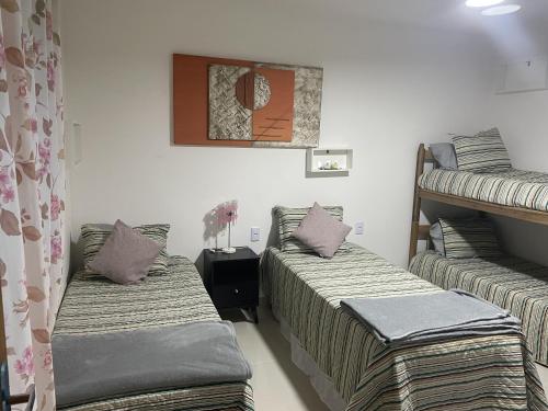 Zimmer mit 2 Etagenbetten und Kissen in der Unterkunft Casa pé na areia - Brandão House in Saco dos Cações