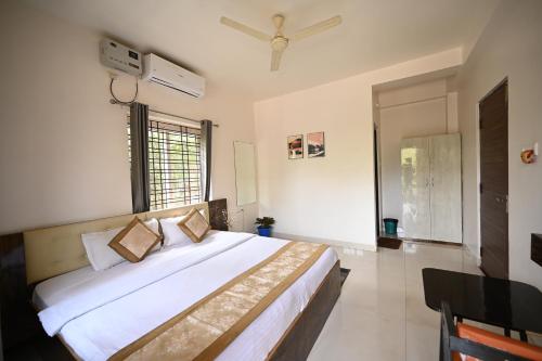 a bedroom with a large bed and a window at Clover Villa Hotels in Bhubaneshwar