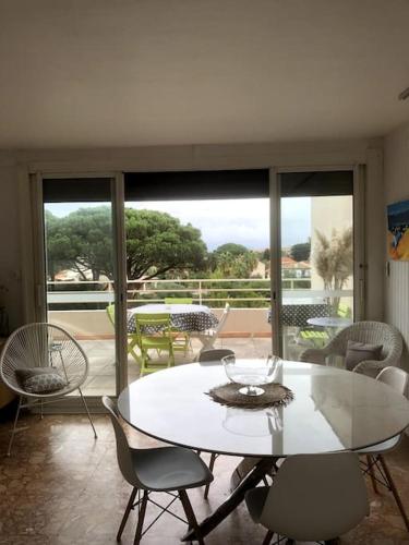 une salle à manger avec une table et des chaises blanches dans l'établissement Brise Tropézienne : Vue Mer / 2 chambres / Parking, à Saint-Tropez