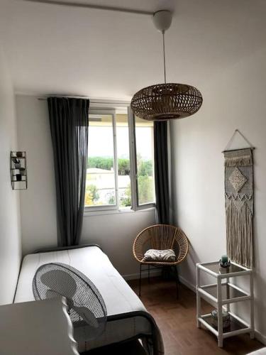 une chambre avec un lit, une chaise et une fenêtre dans l'établissement Brise Tropézienne : Vue Mer / 2 chambres / Parking, à Saint-Tropez