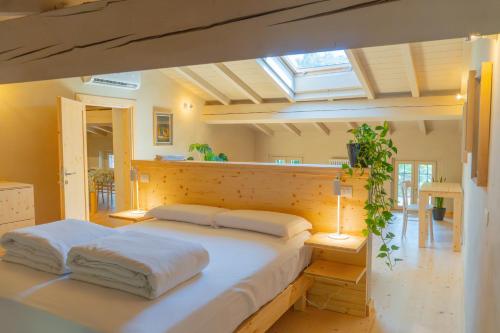 um quarto com uma cama grande e lençóis brancos em Agriturismo Locanda Case Vecie em Grezzana