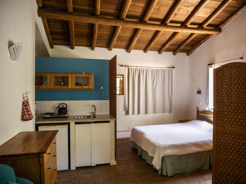 a kitchen with a bed and a sink in a room at Monte Rosa Rural Guesthouse in Lagos