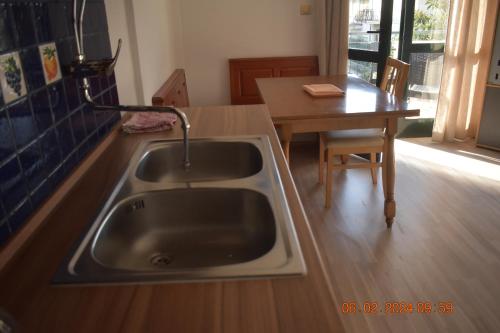 a kitchen with a sink and a wooden table at Trogirsunset Apartments in Trogir
