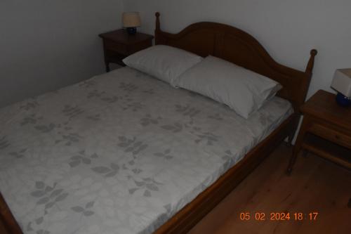 1 dormitorio con cama con almohada y mesita de noche en Trogirsunset Apartments, en Trogir