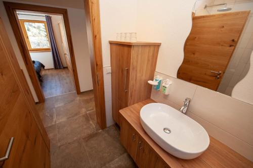 uma casa de banho com um lavatório branco e um espelho. em Apartment Drautalblick em Oberdrauburg