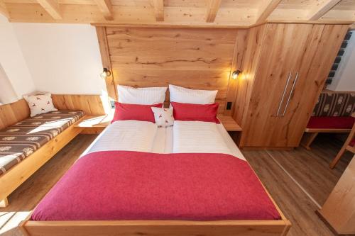 1 dormitorio con 1 cama grande con almohadas rojas y blancas en Apartment Gailtalblick, en Oberdrauburg