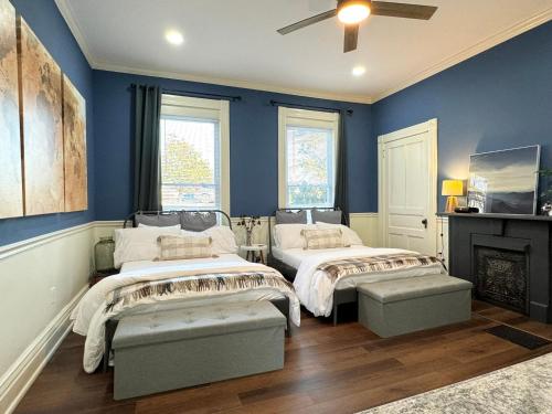 two beds in a room with blue walls at Garden on Capital-Bourbon & Horse Country in Frankfort
