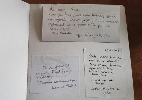 two pieces of paper with writing on a table at Les 3 Bulles in Gueux