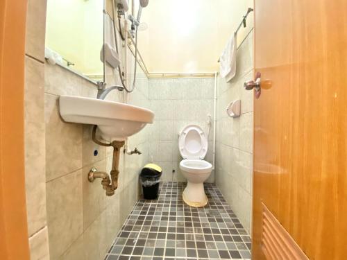 un baño con inodoro y lavabo en Backpackers hostel and transient house, en Nangalisan
