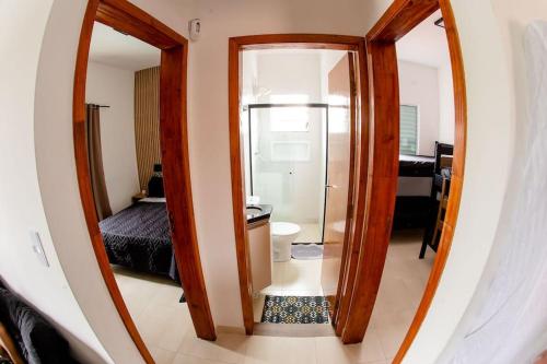 een kamer met een spiegel en een badkamer met een bed bij Apto novo na Praia Grande a 2 minutos da Orla in Praia Grande