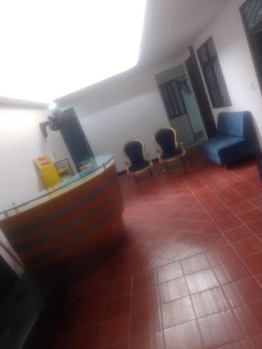 a living room with two chairs and a television at Hotel Olympo in Ibagué