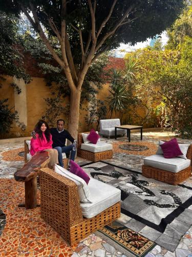 a man and a woman sitting on chairs on a patio at Sakkara pyramid inn hotel in Cairo