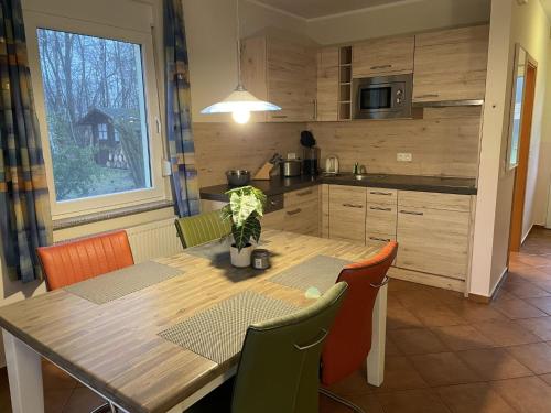 een keuken met een houten tafel met stoelen en een eetkamer bij Holiday Home Möwen und Muschel Nest by Interhome in Ostseebad Karlshagen