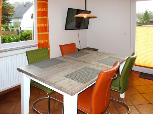 een eettafel met 4 stoelen en een tafel en een raam bij Holiday Home Möwen und Muschel Nest by Interhome in Ostseebad Karlshagen