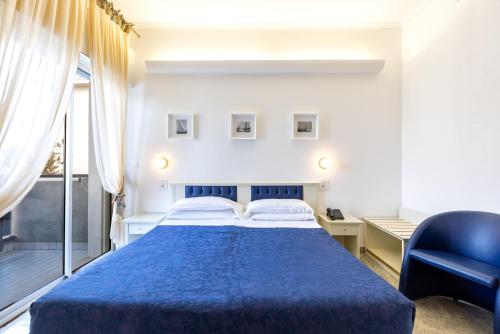 a bedroom with a blue bed and a desk at Hotel Feldberg in Riccione