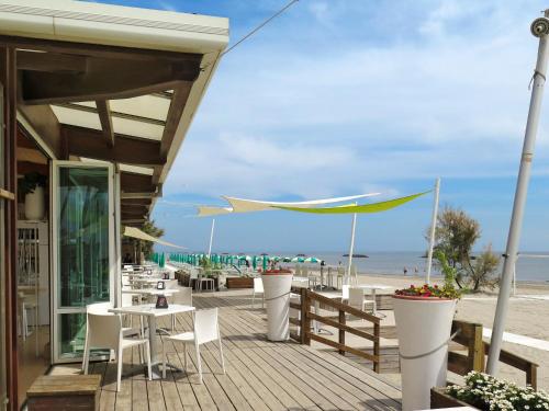 un restaurante en la playa con mesas y sillas en Holiday Home Camping Florenz-3 by Interhome, en Lido di Scacchi