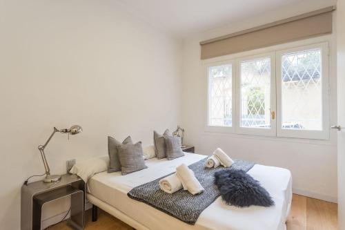 Un dormitorio blanco con una cama con toallas. en My Space Barcelona - 2 Bedroom Apartment in uptown, en Barcelona