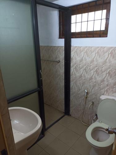 a bathroom with a toilet and a sink at 67 holiday home in Badulla