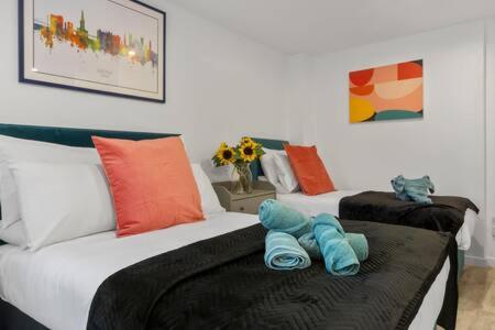 ein Schlafzimmer mit 2 Betten und Handtüchern darauf in der Unterkunft Exeter City Centre Apartments Riley Apartment in Exeter