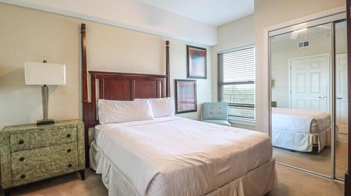 a bedroom with a large bed and a mirror at Legacy II 603 Deluxe in Gulfport