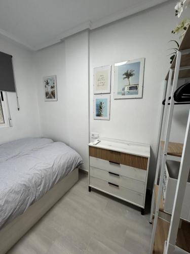 a white bedroom with a bed and a ladder at Skyline 21 in Torrevieja