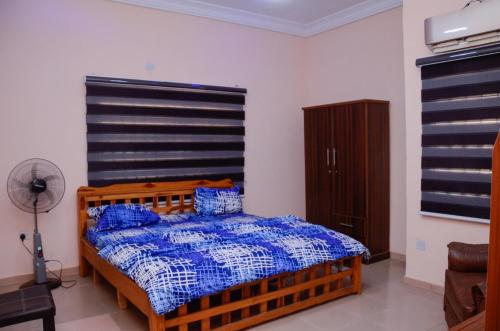 a bedroom with a wooden bed with blue pillows at Peace cottage short lets and apartments in Ibadan