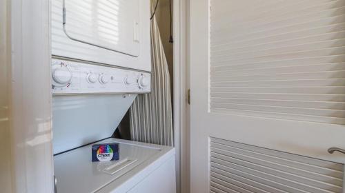een witte koelkast met vriesvak naast een deur bij Oak Shores Studio 36 in Biloxi