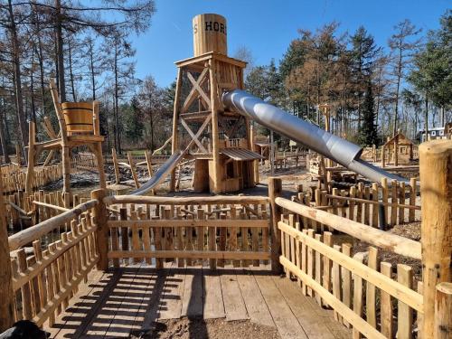 a slide in a playground with a wooden fence at Camping Het Horstmannsbos in Gasselte