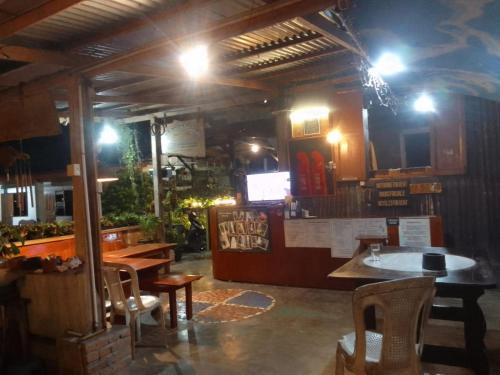 a restaurant with a bar with tables and chairs at Beach Guest House in Maninjau