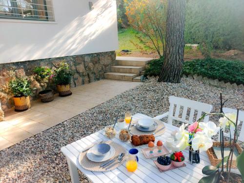 una mesa blanca con comida encima en Casita de Invitados con entrada privada, piscina y aire acondicionado, en Valdemorillo