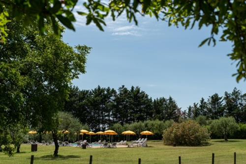 a group of tables and chairs with umbrellas in a park at AGRITURISMO COLOMBARE TEBOI in Lazise
