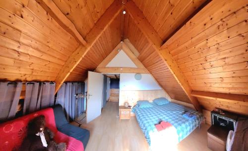 Cette chambre mansardée comprend un lit et un canapé. dans l'établissement chalet avec vue imprenable, à Bagnères-de-Bigorre