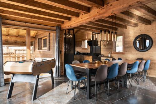 une salle à manger avec une table et des chaises en bois dans l'établissement Chalet Emeraude, chalet de luxe avec vue montagne, à Gérardmer