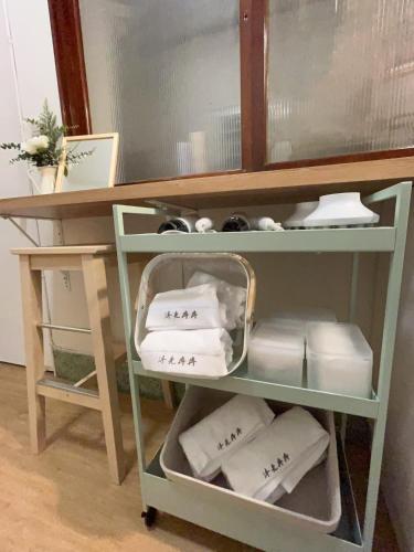 einen Schreibtisch mit einem Regal mit Handtüchern und einem Spiegel in der Unterkunft 沐光冉冉 in Anping