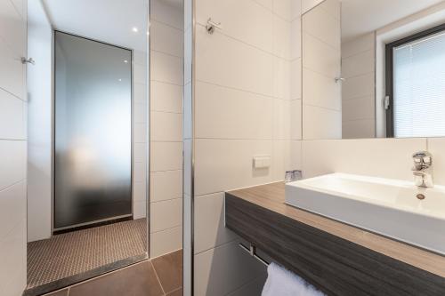 a bathroom with a sink and a mirror at Hotel Lumen Zwolle in Zwolle