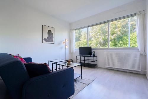 een woonkamer met een bank en een tv bij Functional studio+ Parking close to the tramway in Marcq-en-Baroeul