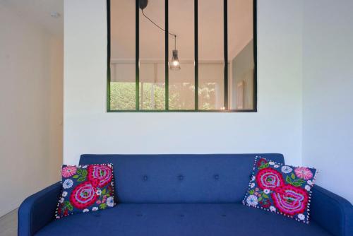 - un canapé bleu avec deux oreillers assis sous un miroir dans l'établissement Functional studio+ Parking close to the tramway, à Marcq-en-Barœul