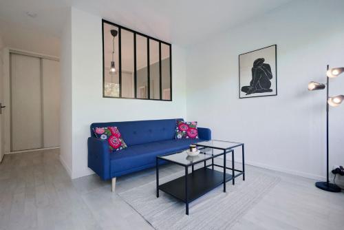 een woonkamer met een blauwe bank en een tafel bij Functional studio+ Parking close to the tramway in Marcq-en-Baroeul